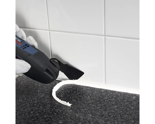 Multifunktionswerkzeug beim Entfernen von Fugenmasse zwischen Fliesen