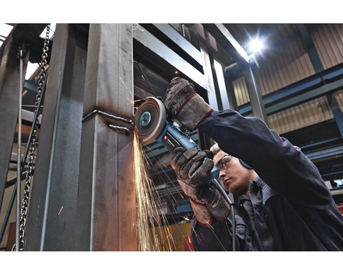Ein Arbeiter benutzt einen Winkelschleifer zum Bearbeiten von Metall, wobei Funken entstehen.