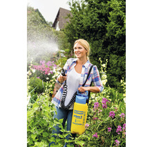 Frau verwendet ein Gloria Prima 5 Gartensprühgerät zur Pflanzenpflege in ihrem Garten.
