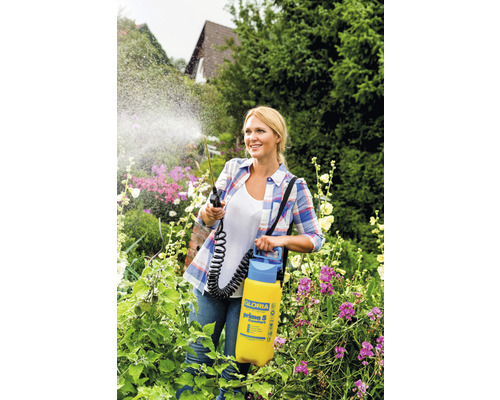 Frau verwendet ein Gloria Prima 5 Gartensprühgerät zur Pflanzenpflege in ihrem Garten.
