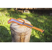 Fuchsschwanzsäge auf einem Holzscheit