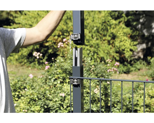 Person montiert einen Zaunpfosten im Garten
