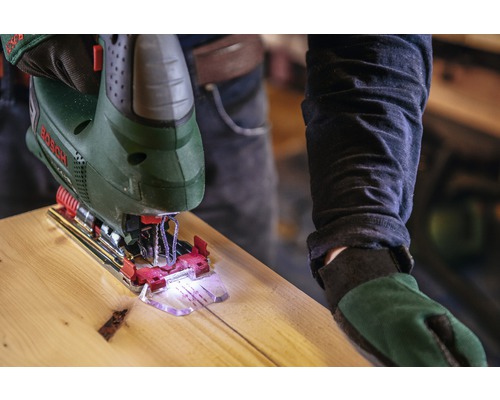 Eine Stichsäge schneidet ein Stück Holz. Bosch Logo.