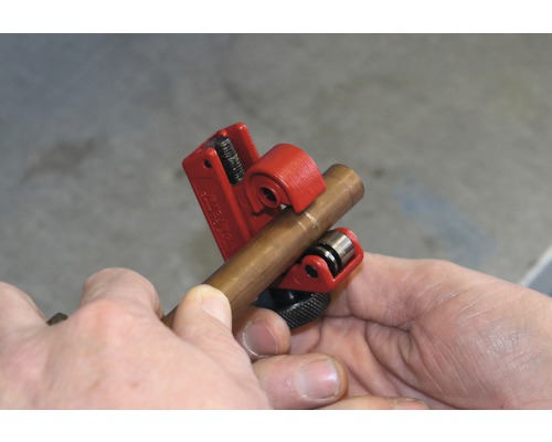 Eine Kupferrohrschneidezange schneidet ein Kupferrohr.