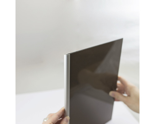 Abschlussprofil Breuer Decodesign rund 2100 mm schwarz matt für 3 mm Rückwände Dunkle Küchenfront mit Aluminiumkante wird von Händen gehalten.