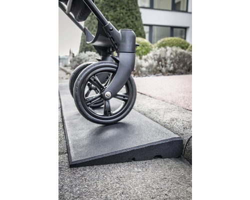 Kinderwagen fährt über eine Bordsteinrampe aus Gummi.