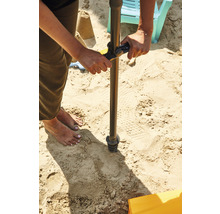 Person bohrt ein Loch in den Sand mit einem Erdlochbohrer.