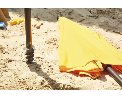 Gelber Sonnenschirm mit Erdanker im Sand