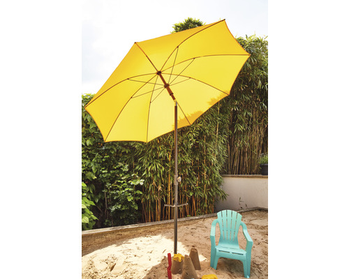 Gelber Sonnenschirm über Sandkasten und Kinderstuhl