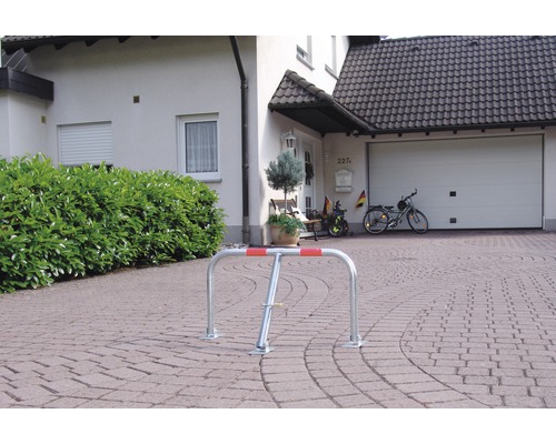 Silberner Fahrradständer mit roter Markierung vor einem Wohnhaus