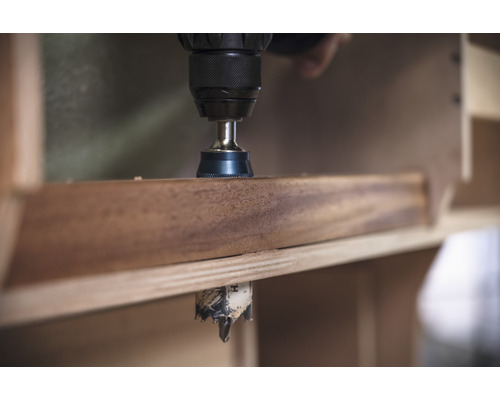 Eine Bohrmaschine bohrt ein Loch in ein Holzbrett.