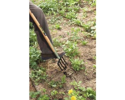 Person verwendet eine Grabgabel zur Gartenarbeit.