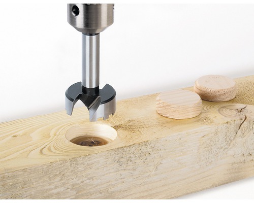 Forstnerbohrer im Einsatz an einem Holzbrett mit Holzstopfen