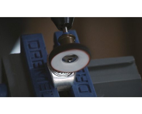 Dremel Werkzeug beim Polieren eines Metallrings in einem Schraubstock