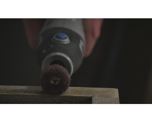 Ein Multifunktionswerkzeug schleift ein Holzstück.