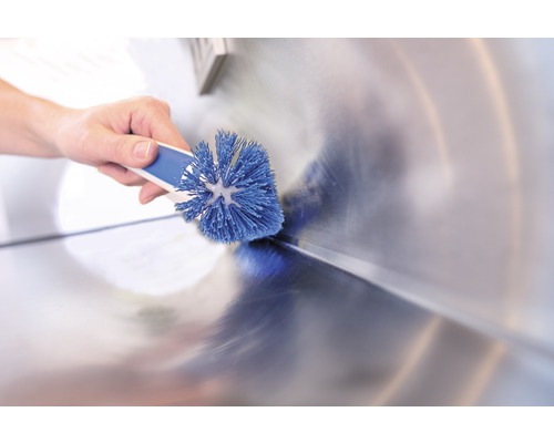 Hand reinigt Waschbecken mit Bürste