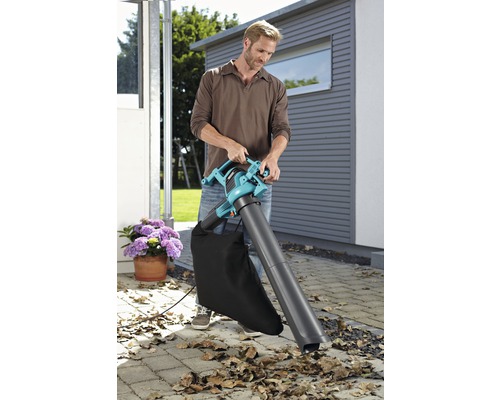 Mann benutzt einen Laubsauger im Garten.