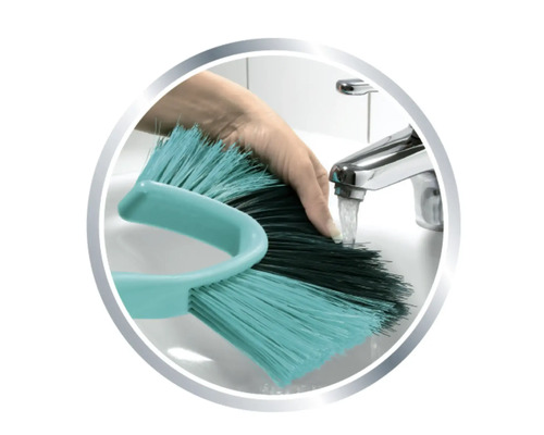 Eine Handwaschbürste wird unter einem Wasserhahn gereinigt.