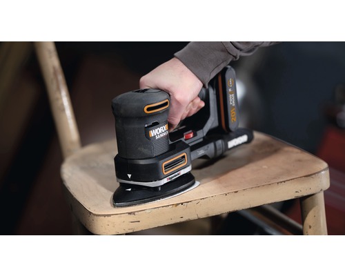 Akkuschleifer beim Schleifen eines Holzstuhls