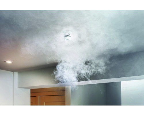 Rauchmelder an der Decke mit Rauch in einem Raum