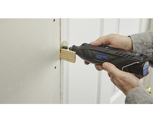 Eine Person benutzt ein Dremel Multifunktionswerkzeug zum Schleifen von Holz.