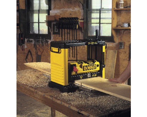 Hobelmaschine im Einsatz mit Holzbrett auf einer Werkbank