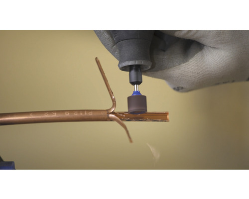 Eine Person benutzt ein Multifunktionswerkzeug zum Schneiden eines Rohres.