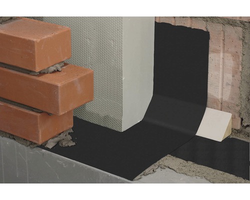 Detailaufnahme einer Horizontalsperre aus Bitumen zwischen Mauerwerk und Beton