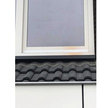 Detailansicht eines Daches mit Ziegeln und einem Fenster.