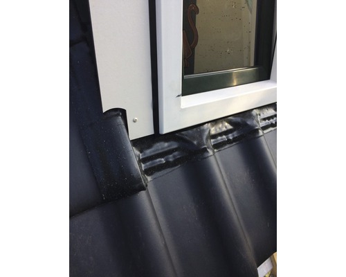 Detailaufnahme eines Dachfensters mit Abdichtung auf einem Ziegeldach