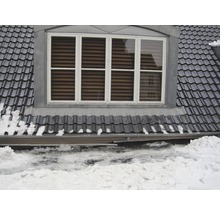 Dachfenster mit Dachziegeln und Schnee