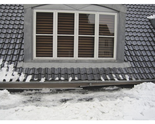 Dachfenster mit Dachziegeln und Schnee