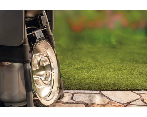 Detailaufnahme eines Gasgrills mit Seitenbrenner auf einer Terrasse