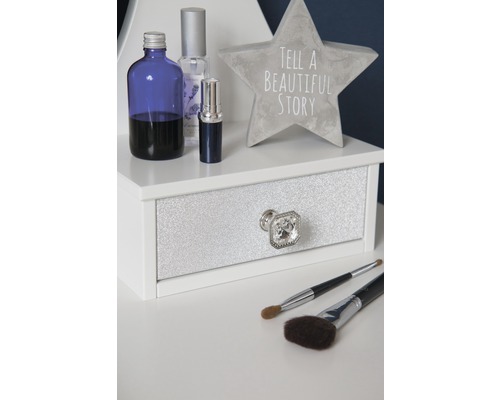 Dekoratives Arrangement mit Flaschen, Sternfigur, Schublade und Make-up-Pinseln