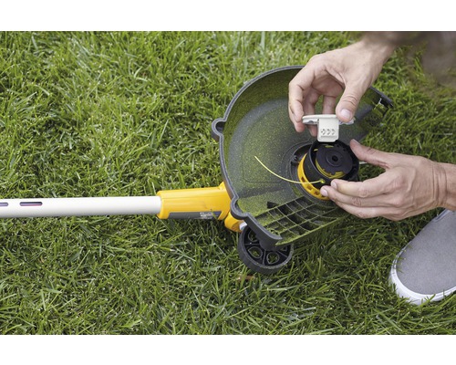 Person wechselt Spule eines Rasentrimmers aus