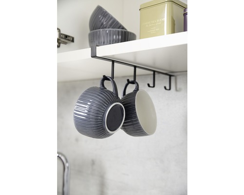 Tassen hängen an einer schwarzen Küchenregalhalterung unter einem Küchenschrank.