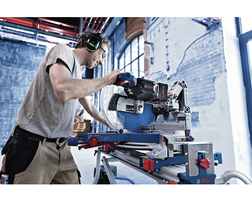 Handwerker bedient eine Bosch Kapp- und Gehrungssäge mit Akku in einer Werkstatt