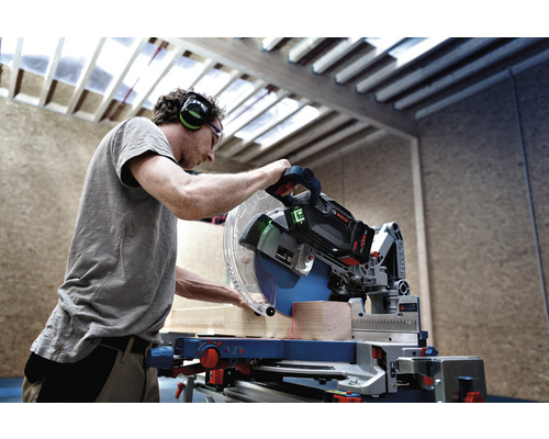 Mann sägt Holz mit einer Bosch Kapp- und Gehrungssäge