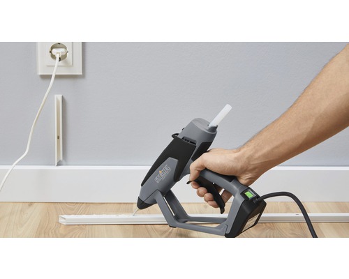 Heißklebepistole im Einsatz zum Anbringen einer Zierleiste