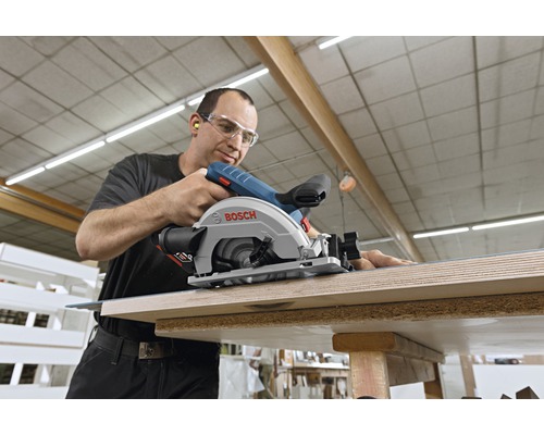 Ein Mann benutzt eine Bosch Handkreissäge zum Schneiden von Holz.