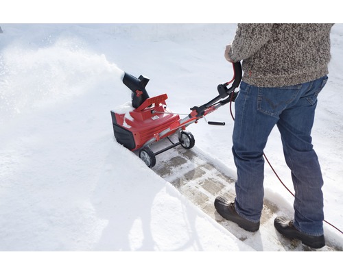 Person benutzt eine Schneefräse zum Schneeräumen