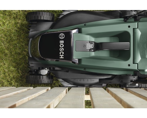 Draufsicht auf einen Rasenmäher der Marke Bosch auf Gras und Holz