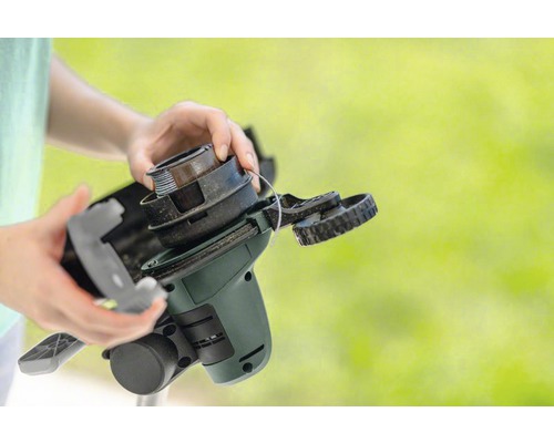 Hände wechseln Spule eines Rasentrimmers