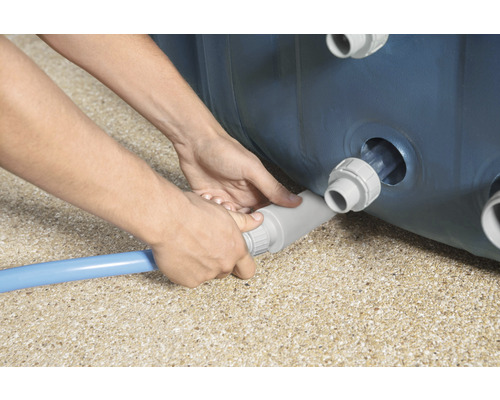 Eine Person schließt einen Poolschlauch an einen Pool an.