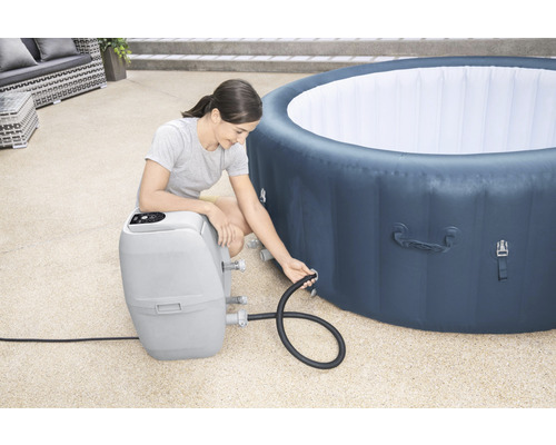 Frau schliesst eine aufblasbare Badewanne an eine Filterpumpe an
