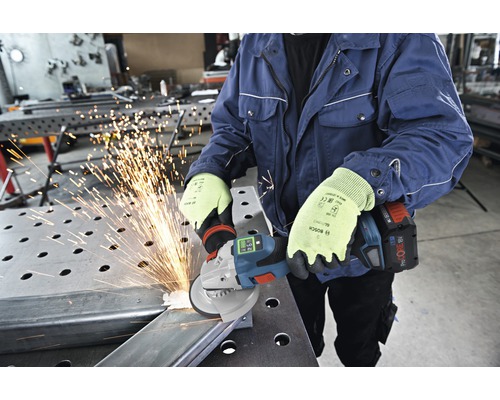 Eine Person benutzt einen Akku-Winkelschleifer zum Schneiden von Metall, wobei Funken entstehen.