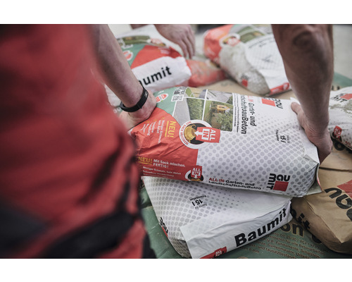 Mehrere Säcke Baumit Garten- und Landschaftsbau Beton liegen auf einem Tisch.