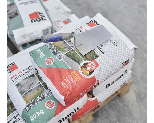 Palette mit Säcken Baumit All In Gartenlandschaftsbeton und einer Maurerkelle