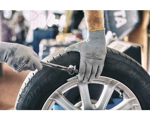 Reifenmontage mit Schutzhandschuhen und Werkzeug
