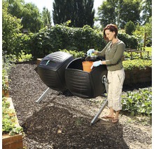 Gartenszene mit Frau, die einen Trommelkomposter mit einem Topf befüllt